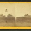 Veiw of a lighthouse with a man standing in the foreground.