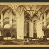 Interior view of the Baptist chapel showing seats and pews and the organ above the altar.