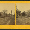 View of street with large buildings and a church.