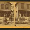 Miss Olive Jones sitting sidesaddle on her horse as others look on from the porch of a home.