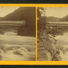 View of a bridge over a rushing stream.