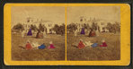 View of group playing croquet, man holding woman's skirt aside for her.