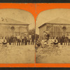 Group of boys and girls in front of unidentified brick structure.