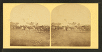 View of a fairgrounds(?), showing people and large tents.