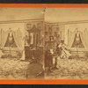 Interior view of a parlor with a woman sitting near a window.