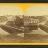 View of a bridge over a river, town in background.