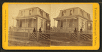 View of a house, two people standing in front.