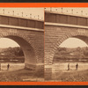 View of two people standing under completed arch.