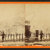 Individual standing next to a gate to Boston Common in the winter.
