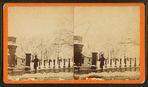 Individual standing next to a gate to Boston Common in the winter.