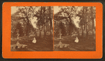 Woman seated at table with fountain, swing, and bench nearby.