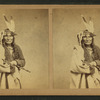 Studio portrait of Chippewas chief, O-gee-tub (Heavy sitter), holding a pipe.