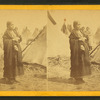 Portrait of a Sioux (Dakota) woman in front of teepees.