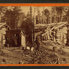 Woman stands in doorway of log cabin on the Northern Pacific Road.