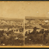 General view of city with buildings, houses, and a bridge over the Mississippi.