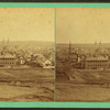 General view of city with houses, buildings, and churches.