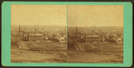 General view of city with houses, buildings, and churches.