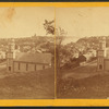 View of Stillwater from a hill, including businesses, houses, and a church.