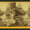 View of a river, with both banks, rock formations, and trees.