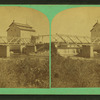 View of a bridge and a building (possibly a mill) near the falls of a small river.