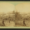 View of two people with saw mill in the background.