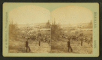 View of two people with saw mill in the background.
