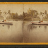 Man in boat on lake, next to fountain.]