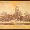 Group of men in front of a log cabin.