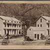 View of horse-drawn wagon approaching house.