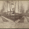 View of a paved walk with cadets lined up along border of trees.