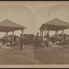 Group of people standing under a shelter.