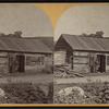 Man standing in front of his cabin, in or near Wevertown, N.Y.