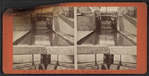 View of locks, showing a boat locking through, Lockport, N.Y.
