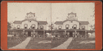 View of people standing in the verandah and one man standing on the roof.