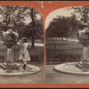 Drinking fountain on the mall. [Girl in a dress at the fountain.]