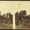 Men and children pose before stockade fence under bent tree trunk arch, Luzerne County, Pa.