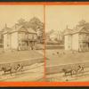 Three-story frame house on terraced yard; people pose on porch; young man holds reins in one-horse carriage. Retaining wall and street under construction.