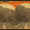 Railroad tunnel and tracks through mountain.