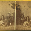 Studio portrait of three Native American children in traditional clothing.
