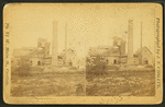 Industrial building with inclined plane and large smokestack.