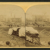 A view taken from the rear of the P. R. R. depot. In the middle ground are seen the stores and offices of the Cambria Iron Co., and in the foreground are coffins and bodies just arrived from the morgues and ready for shipment.
