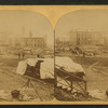 A view taken from the rear of the P. R. R. depot. In the middle ground are seen the stores and offices of the Cambria Iron Co., and in the foreground are coffins and bodies just arrived from the morgues and ready for shipment.