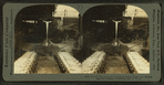 Front view of ladle emptying molten iron into moulds, pig iron machine, Pittsburg, Pa., U.S.A.