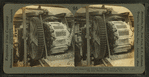 Emptying cooled pig iron from molds into car, pig iron machine, Pittsburg, Pa.