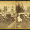 A boy and girl sitting outside and playing with dollhouses, baby carriage and doll.