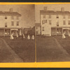 Group playing croquet in front of house or boarding house.