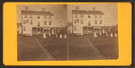 Group playing croquet in front of house or boarding house.