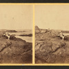 View of a family sitting on the rocks and viewing the ocean.