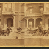 People in coach with African American coachmen, in front of house.