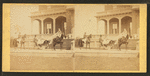 People in coach with African American coachman, in front of house.